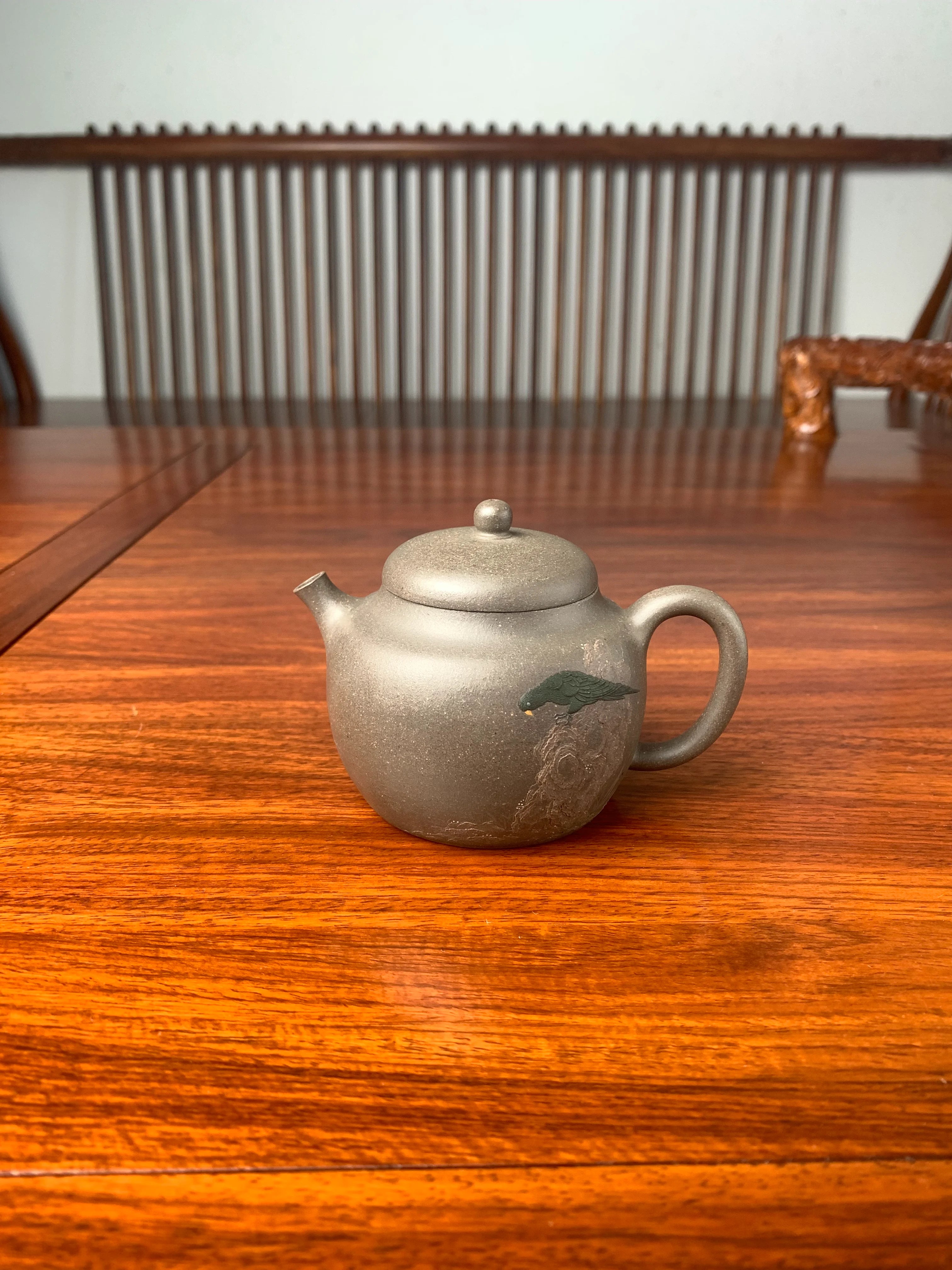 teapot artwork named green parrot on the table